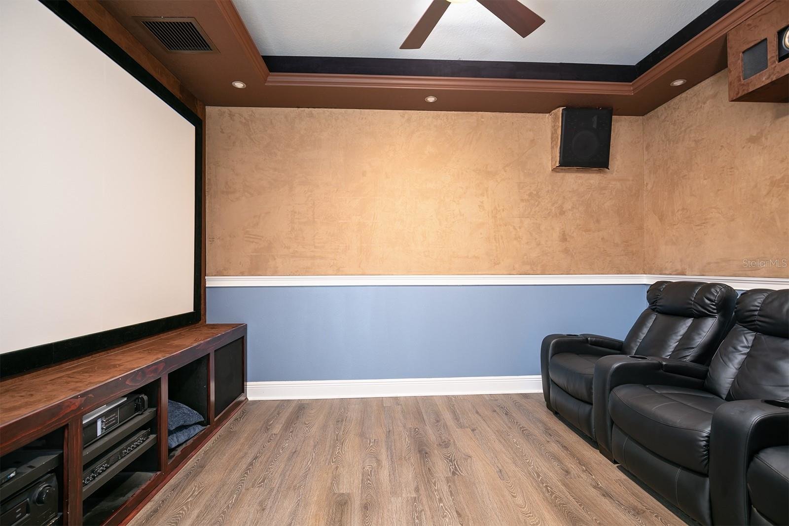 movie room with projector and black recliners